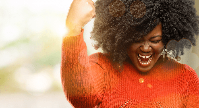 Beautiful african woman happy and excited expressing winning gesture. Successful and celebrating victory, triumphant, outdoor