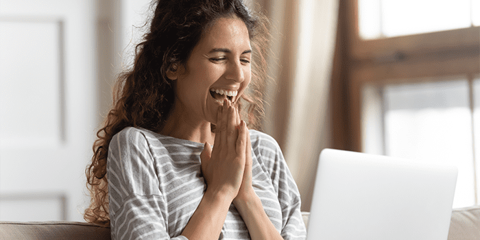 Excited woman looking at laptop screen, rejoicing good news, happy laughing girl reading email or message in social network, win online lottery, great shopping offer, sitting on cozy sofa at home